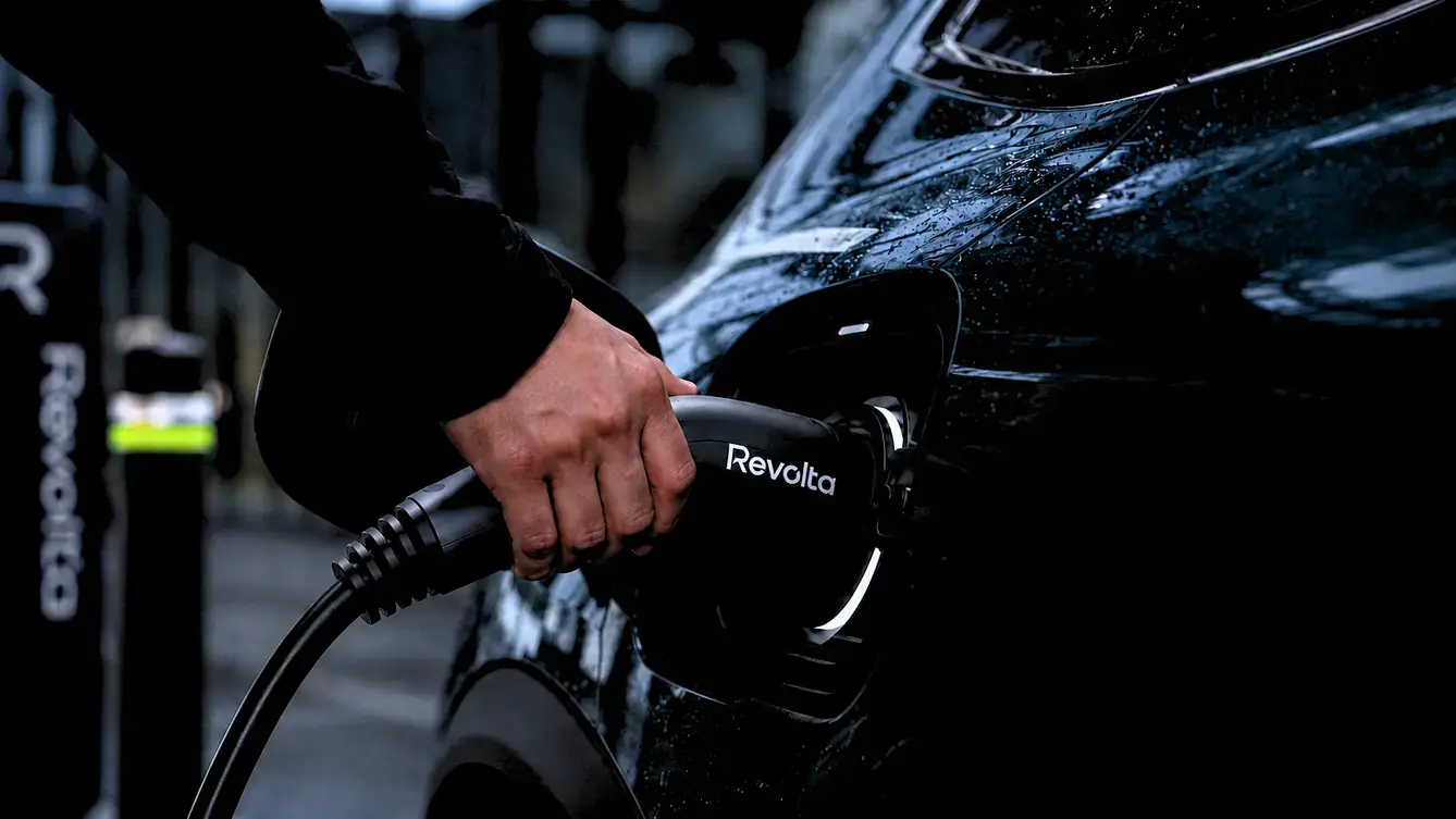 Persona conectando un coche eléctrico